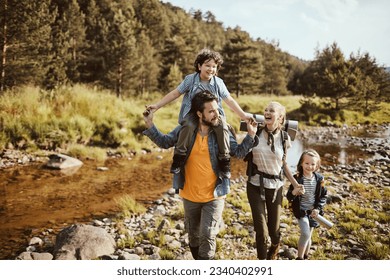 Young family hiking in the forest next to a creek - Powered by Shutterstock