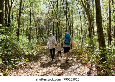 Young Family Hiking In The Woods In Autumn