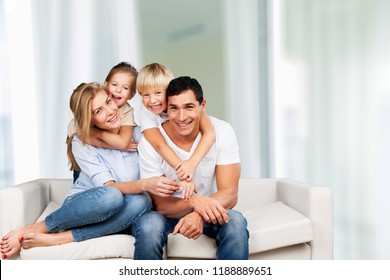 Young Family At Home Smiling At Camera