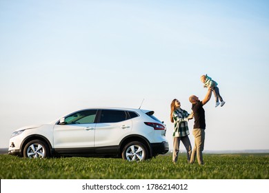 Young Family With Kids Travelling By Car, Stopped In The Field