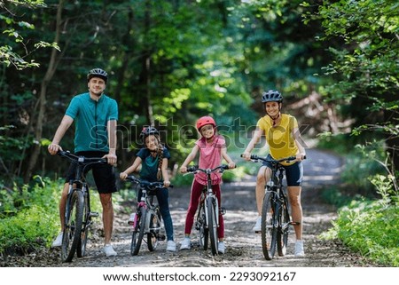 Young family with little children at bike trip together in nature.