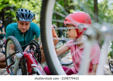 Young family with little children preapring for bike ride, standing with bicycles in nature. - Powered by Shutterstock