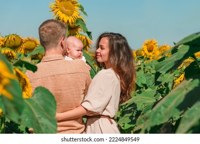 A Young Family With A Little Cute Baby In A Field Of Sunflowers. Happy Summer, Family Activities And Outdoors Lifestyle.