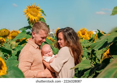 A Young Family With A Little Cute Baby In A Field Of Sunflowers. Happy Summer, Family Activities And Outdoors Lifestyle.