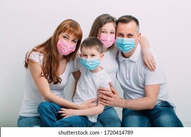 Young Family In Medical Masks During Home Quarantine