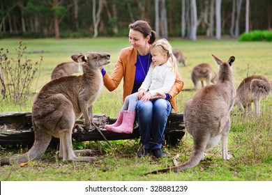 Young Family Of Mother And Daughter Feeding Kangaroo At Zoo