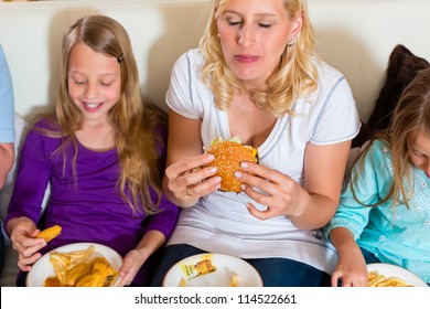 Young Family - Mother And Daughters - Is Eating Hamburger Or Fast Food At Home