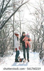 Young Family - Mother, Father, Baby And Dog In A Winter Park.