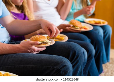 Young Family - Mother, Father And Daughters - Is Eating Hamburger Or Fast Food At Home