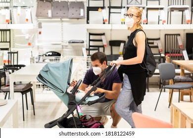 Young Family With Newborn In Stroller Shopping At Retail Furniture And Home Accessories Store Wearing Protective Medical Face Mask To Prevent Spreading Of Corona Virus When Shops Reopen.