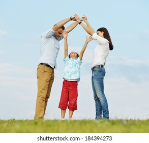 Young Family On Green Summer Grass Meadow Building Dream New Home