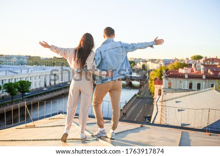Young family on rooftop enjoying with view of beautiful european city