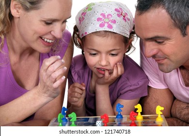 Young Family Playing A Board Game