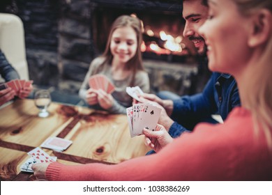 Young family playing card game at home