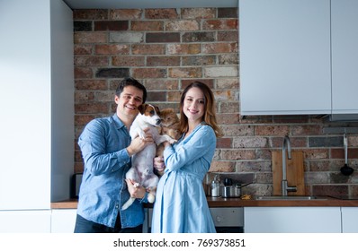 Young Family, Pregnant Woman And Her Partner Or Husband With Dog And Cat At Kitchen