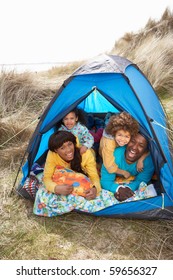 Young Family Relaxing Inside Tent On Camping Holiday