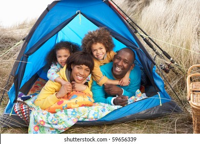 Young Family Relaxing Inside Tent On Camping Holiday