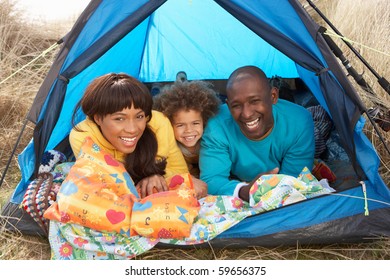 Young Family Relaxing Inside Tent On Camping Holiday