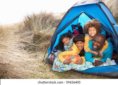 Young Family Relaxing Inside Tent On Camping Holiday