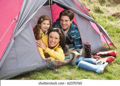 Young Family Relaxing Inside Tent On Camping Holiday