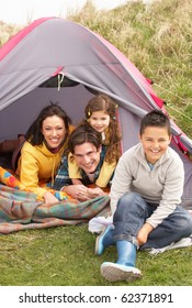 Young Family Relaxing Inside Tent On Camping Holiday