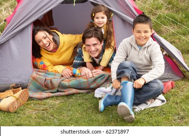 Young Family Relaxing Inside Tent On Camping Holiday