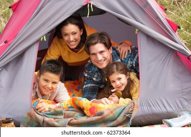 Young Family Relaxing Inside Tent On Camping Holiday