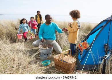 Young Family Relaxing On Beach Camping Holiday