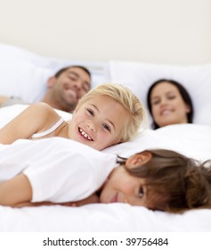 Young family relaxing together in parent's bed