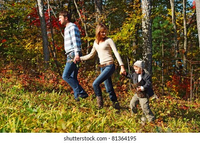 Young Family Resting In The Fall Forest