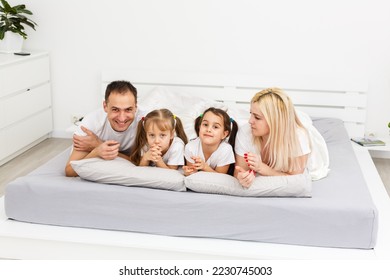 Young family resting together in parent's bed - Shutterstock ID 2230745003