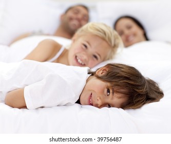 Young family resting together in parent's bed - Powered by Shutterstock