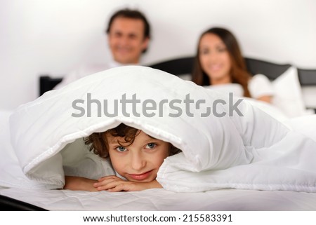 Young family resting together in parent's bed