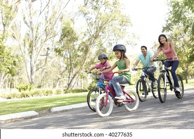 Young Family Riding Bikes In Park