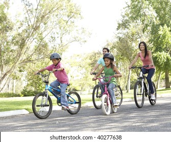 Young Family Riding Bikes In Park