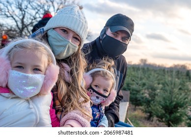 Young Family Riding A Wagon At The Christmas Tree Farm In Winter