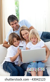 Young Family Shopping Online In The Living-room