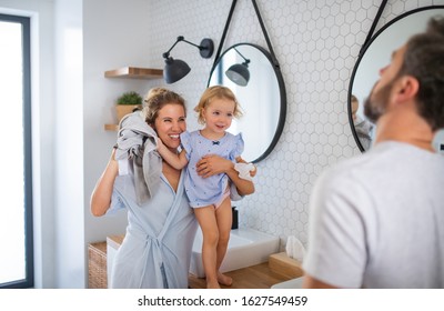 Young Family With Small Daughter Indoors In Bathroom, Talking.
