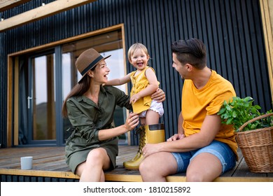 Young Family With Small Daughter Outdoors, Weekend Away In Container House In Countryside.