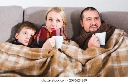 Young family with son catching cold, wrapping in blanket - Shutterstock ID 2076624289