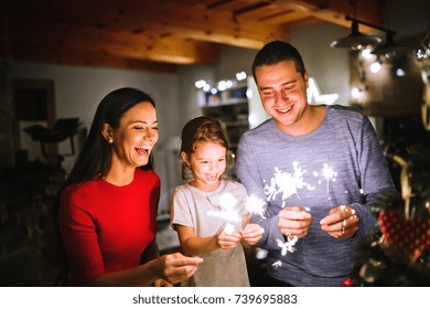 Young family with sparklers at Christmas time at home. - Powered by Shutterstock