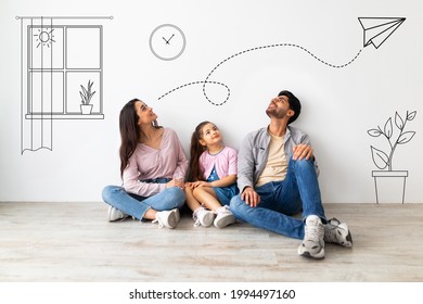 Young family of three imagining interior of their new flat, sitting on floor near white wall with doodle drawings, planning relocation. Creative collage with illustrations on background - Shutterstock ID 1994497160