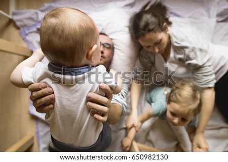 Similar – Relaxed mother and sons playing over the bed