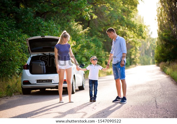 young family travels by car. Dad,\
mom and little son take a break from driving a car and\
walk.