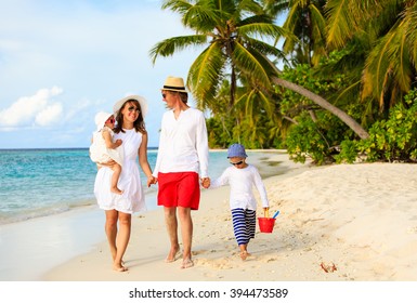 Young Family With Two Kids Walking At Tropical Beach