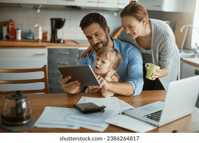 Young family using tablet with documents on desk - Powered by Shutterstock