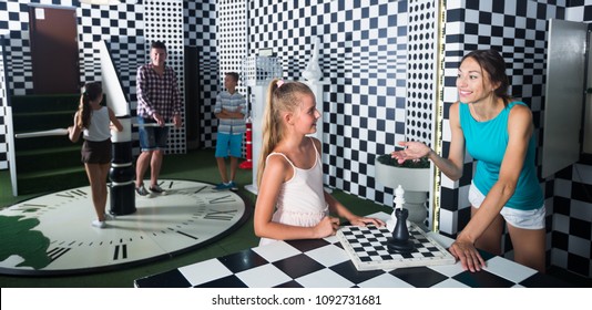 Young Family Is Visiting Of Escape Room Stylized Under Chessboard.