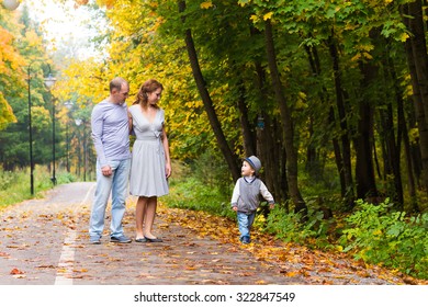 Young family for a walk in a autumn park with baby