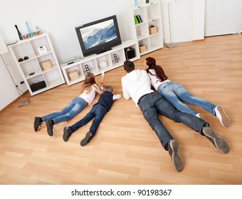 Young Family Watching TV Together At Home