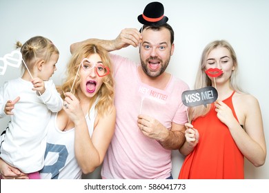 Young Family At White Background Photo Booth With Party Props Happy Funny Smile Strike Pose Celebration Wedding Anniversary 